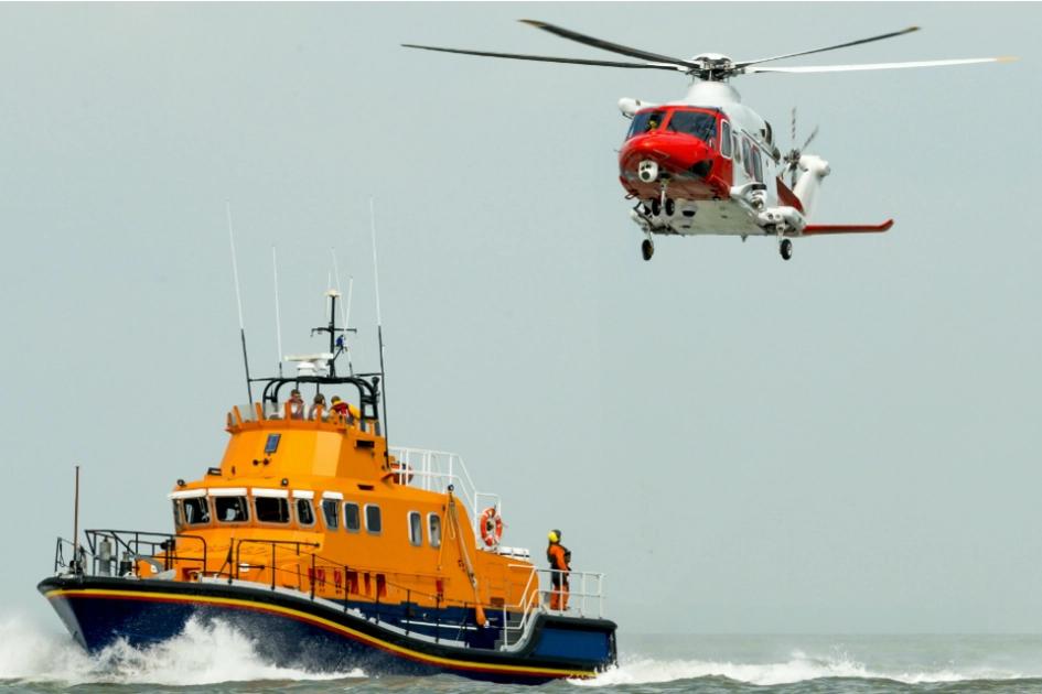 en livräddningsbåt ute till havs med en helikopter ovanför.jpg