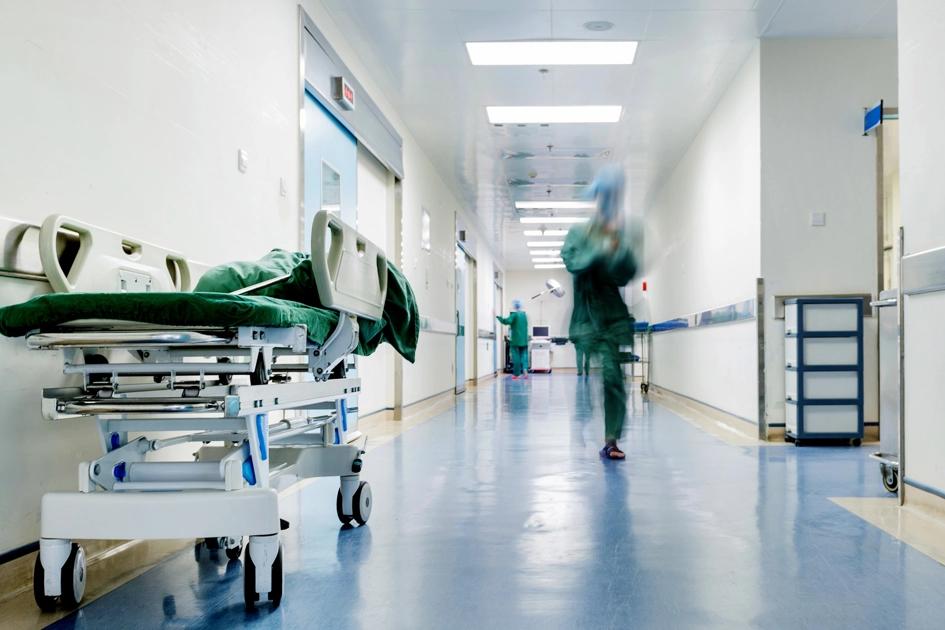korridor i sjukhus med en kvinnar i scrubs som springer.jpg (1)