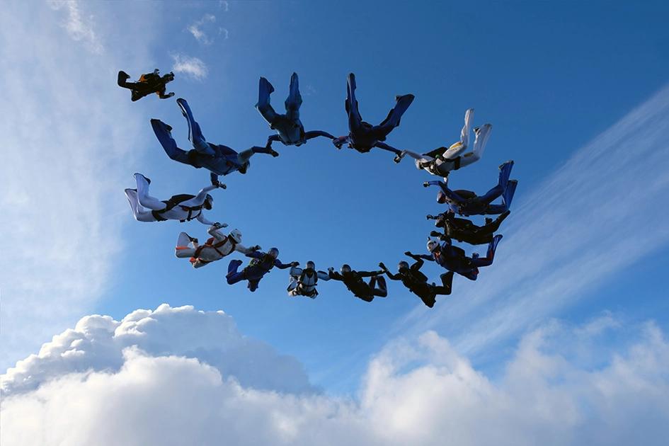 folk flyger i ring i luften med fallskärmar.jpg