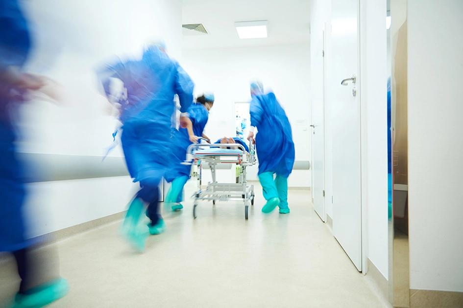 sjuksköterskor och läkare springer med patient på bår i sjukhuskorridor.jpg