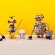 tre söta robotar städar mot gul bakgrund.jpg