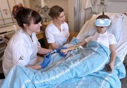 Tre Sjuksköterskor Och Ett Barn Med Vr Glasögon I En Sjukhussäng; Vr, Region, Skåne