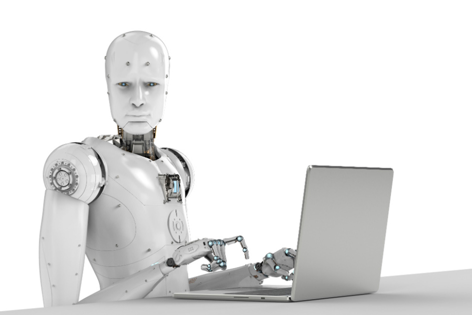 robot sitter vid en laptop och tittar mot kameran.jpg