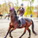 tjej som rider dressyrhäst i dressyrhage en fin dag med folk i bakgrunden.jpg