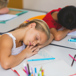 tjej och kille ligger och sover på sina bänkar i skolan.jpg