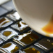 närbild på ett tangentbord med en kaffekopp med utspilt kaffe.jpg