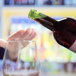 vin ska hällas upp i ett glas men en hand håller för vinglaset.jpg