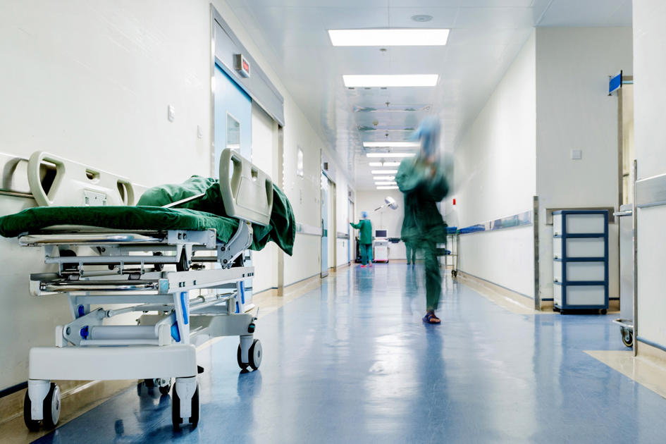 korridor i sjukhus med en kvinnar i scrubs som springer.jpg