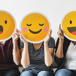 tre personer i en soffa med glada emojisar i papper framför sina huvuden2.jpg