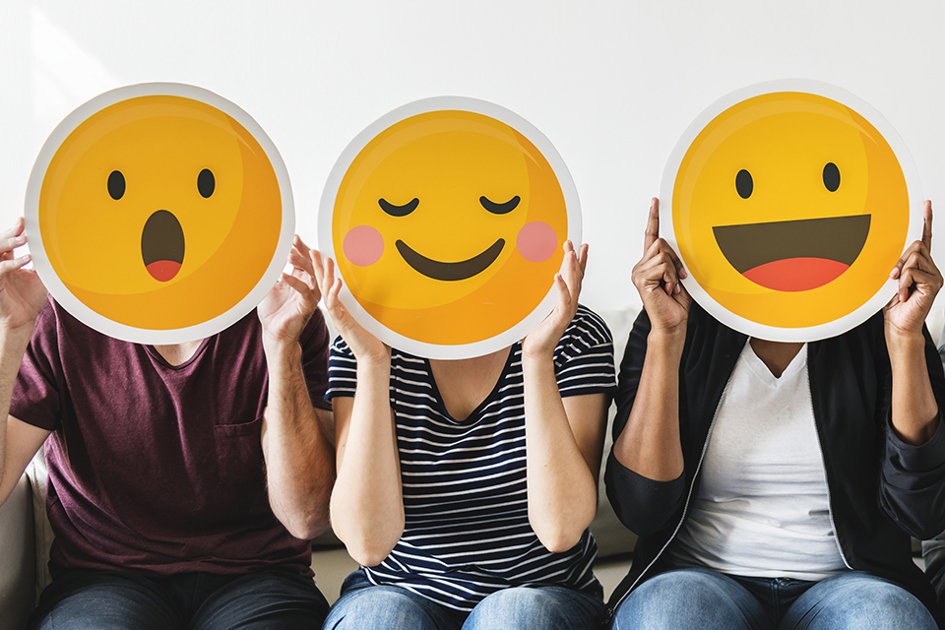 tre personer i en soffa med glada emojisar i papper framför sina huvuden2.jpg
