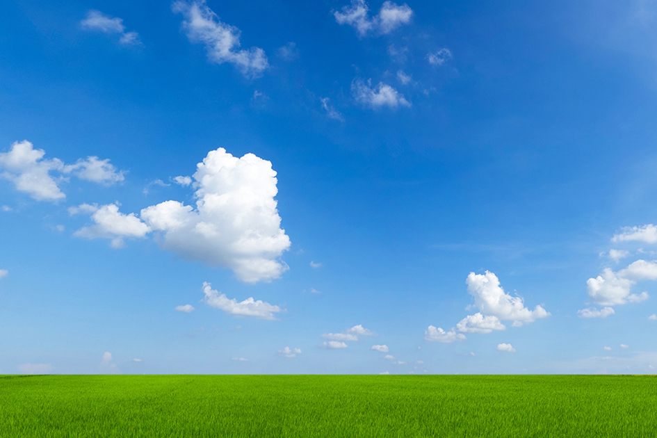 grön gräsmatta blå himmel och ett par vita moln.jpg