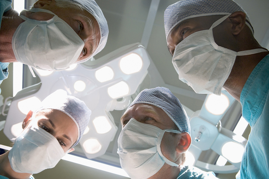 Fyra Kirurger Behandlar Patient